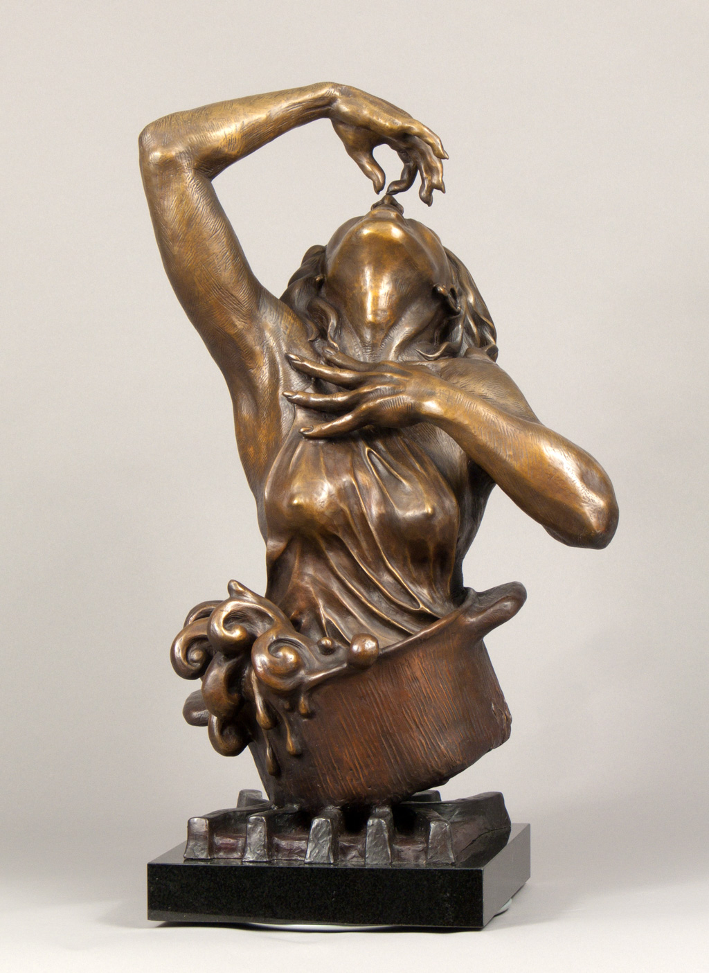 A bronze sculpture of a woman coming out of a pot
